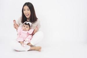 Asian mother and adorable baby girl are  happy on white background photo