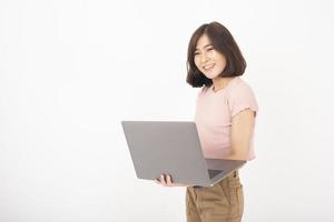 Una linda adolescente asiática está trabajando con una computadora de fondo blanco foto
