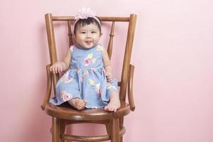 Adorable Asian baby girl is portrait on pink  background photo