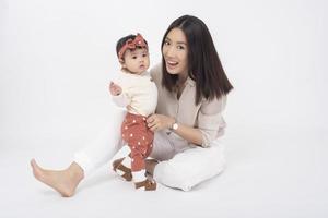 Asian mother and adorable baby girl are  happy on white background photo