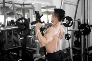 Muscular fitness hombre culturista está entrenando en el gimnasio foto