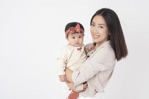 Asian mother and adorable baby girl are  happy on white background photo