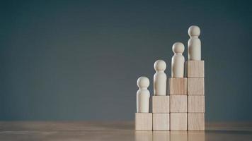 Wooden peg dolls on Stack of wooden blocks. Employees positions. Human resource management planning. photo