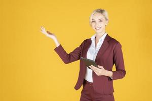 Business woman is presenting something on yellow  background photo