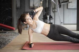 Beautiful asian woman is doing exercise in the gym photo