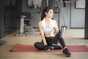 Beautiful asian woman is doing exercise in the gym photo