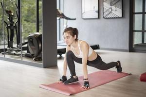 Beautiful asian woman is doing exercise in the gym photo