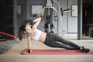 Beautiful asian woman is doing exercise in the gym photo