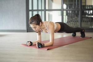 Beautiful asian woman is doing exercise in the gym photo