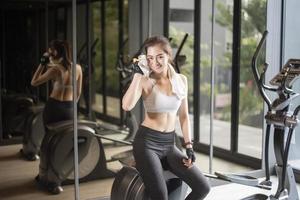 Beautiful asian woman is doing exercise in the gym photo