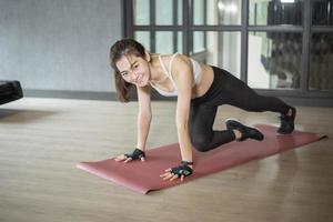 Beautiful asian woman is doing exercise in the gym photo