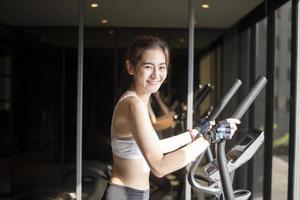 Beautiful asian woman is doing exercise in the gym photo