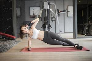 Beautiful asian woman is doing exercise in the gym photo