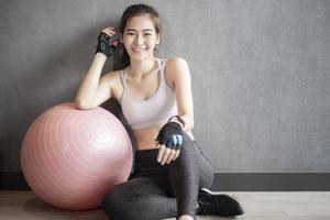 Beautiful asian woman is doing exercise in the gym photo