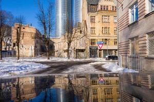 riga, letonia, 20 de febrero de 2021. calle de invierno en la ciudad de riga, letonia. calle estrecha durante el invierno soleado. foto