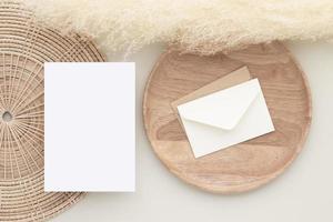 tarjetas de papel en blanco, maqueta con pasto de la pampa en una placa de madera, fondo beige, composición mínima de lugar de trabajo beige, plano, maqueta foto
