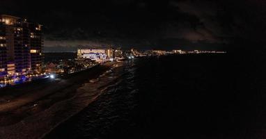 vista aérea del hotel de lujo por la noche junto al mar con una enorme piscina infinita. foto