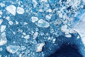 Ice texture background. Textured cold frosty surface of ice block on dark background. photo