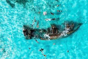 People snorkelling around the ship wreck near Cancun in the Caribbean sea.