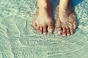 Closeup of feet in coastline , Reflection light. photo