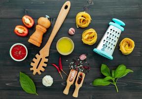 The  pasta on black wooden background. Yellow italian pasta with ingredients. Italian food and menu concept. photo