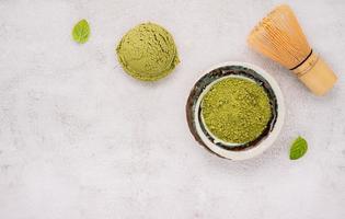 Matcha green tea ice cream with green tea powder and mint leaves  setup on white stone background . Summer and Sweet menu concept. photo