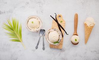 sabores de helado de coco en la mitad de la instalación de coco sobre fondo de piedra blanca. concepto de menú de verano y dulce. foto