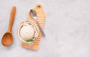 Coconut ice cream flavours in half of coconut setup on white stone background. Summer and Sweet menu concept. photo