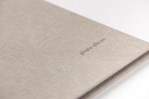 Grey hardcover photo album on white background. Close-up