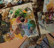 a lot of used tubes of art paint, brush. top view. concept artistic and creative chaos photo