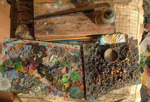 pintura de arte mixto en el tablero, pincel y tubo. la vista desde arriba. concepto de caos artístico y creativo foto