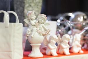 figurines of angels and a bag on a shelf in a store photo