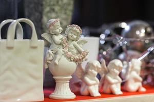 figurines of angels and a bag on a shelf in a store photo