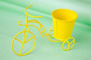 souvenir toy metallic bicycle with a bucket on a green background photo