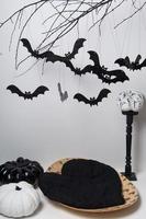 halloween silhouettes with many black bats on a tree branch and a pumpkin on a white background