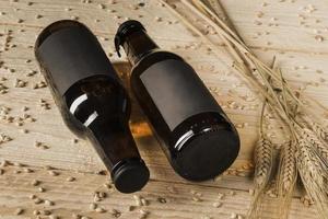 close up two beer bottles ears wheat wooden background photo