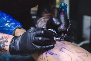 manos recortadas haciendo tatuaje con máquina