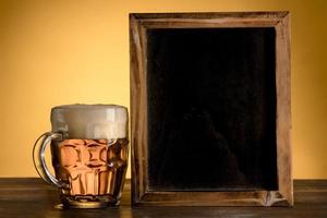 empty blackboard with glass beer wooden table photo
