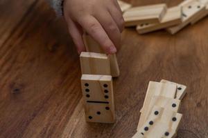 child's hands playing dominoes with blurred focus photo
