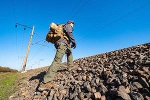 Male traveler with tactical and militari equipment walk alone in sunny day photo