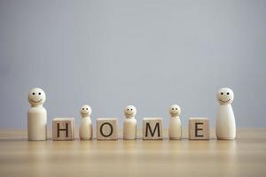 Happy wood family person model a smiley with word home on wood cube table background photo