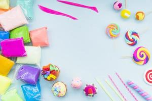 colorful clay plastic bag with fake cake lollipop blue background