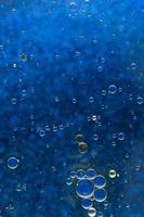 abstract blue background with oil bubbles floating water surface photo