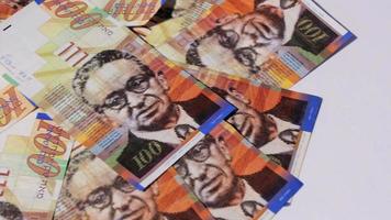 Stack of Israeli money bills of 100 shekel - Pan left