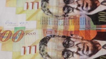 Stack of Israeli money bills of 100 shekel - Tilt down video