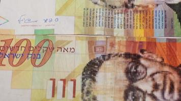 Stack of Israeli money bills of 100 shekel - Tilt down video