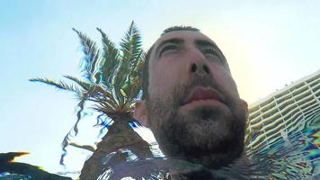 Underwater view of a young Israeli man looking around thoughtfully and expressionless in a swimming pool