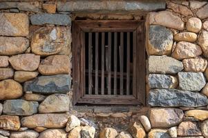There is a window on the stone wall photo