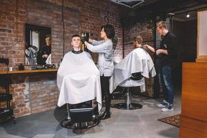 Hairdressers cut their clients in barbershop. Advertising and barber shop concept photo