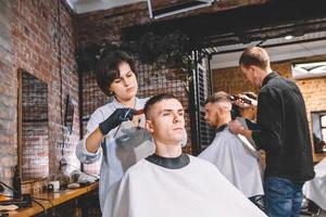 Hairdressers cut their clients in barbershop. Advertising and barber shop concept photo